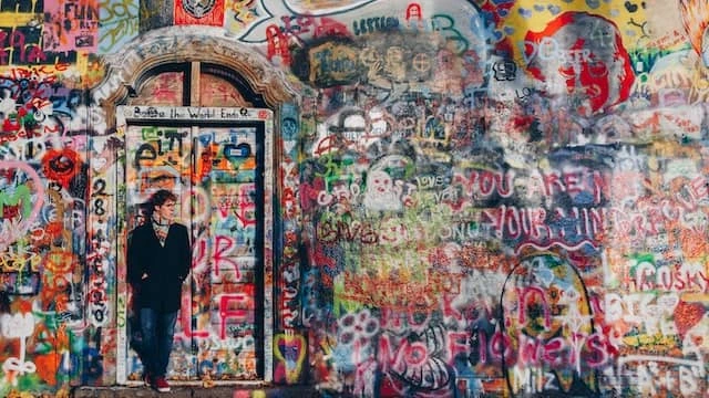 John Lennon Mauer mit Person vor Tür